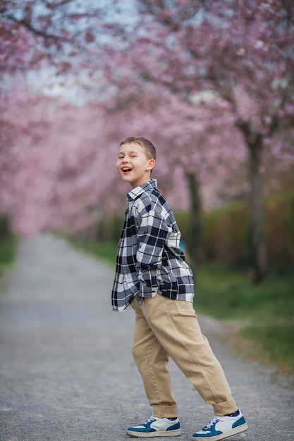 Um menino em um skate com flores cor de rosa ao fundo