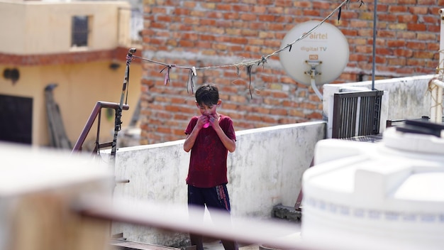 Um menino está enchendo um balão na imagem holi