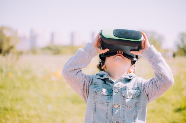 Um menino está jogando óculos de realidade virtual na rua Gadgets modernos Jogos infantis A escolha de óculos virtuais Um artigo sobre óculos virtuais Crianças modernas