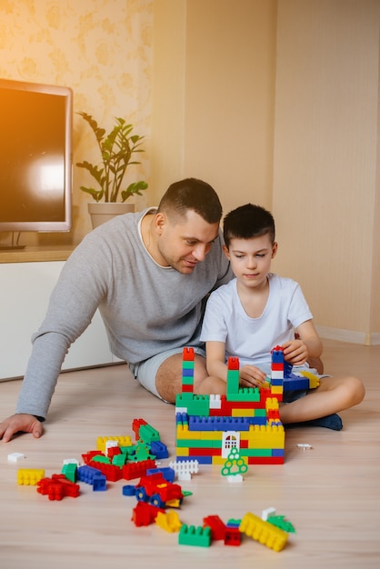 Um menino junto com seu pai é interpretado por um construtor e constrói uma casa. Construção de uma casa de família.