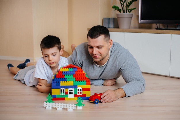 Um menino junto com seu pai é interpretado por um construtor e constrói uma casa. Construção de uma casa de família.