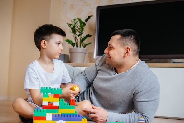 Um menino junto com seu pai é interpretado por um construtor e constrói uma casa. Construção de uma casa de família.