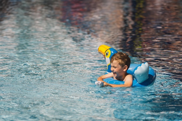 Um menino numa piscina num dia ensolarado