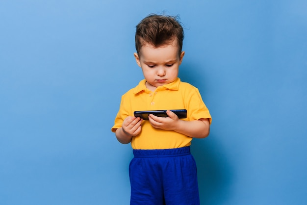 Um menino olha para a tela de um telefone celular.