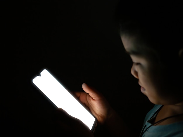 Um menino olhando para uma tela de telefone em branco