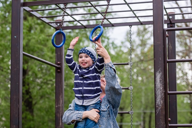 Um menino pequeno e sua mãe em um parque infantil