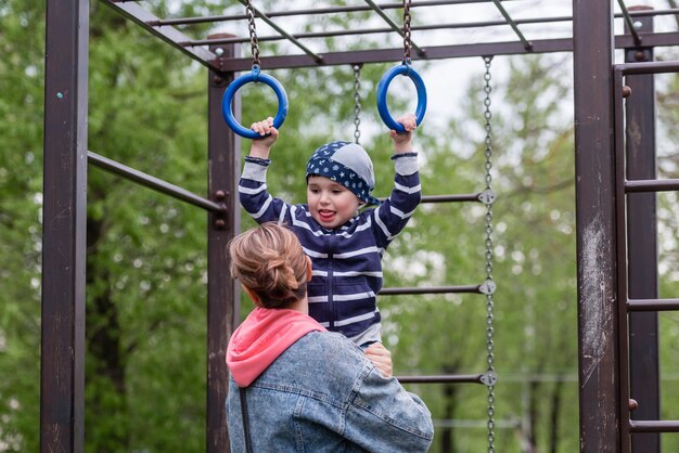 Um menino pequeno e sua mãe em um parque infantil