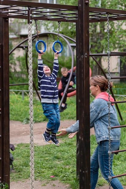 Um menino pequeno e sua mãe em um parque infantil