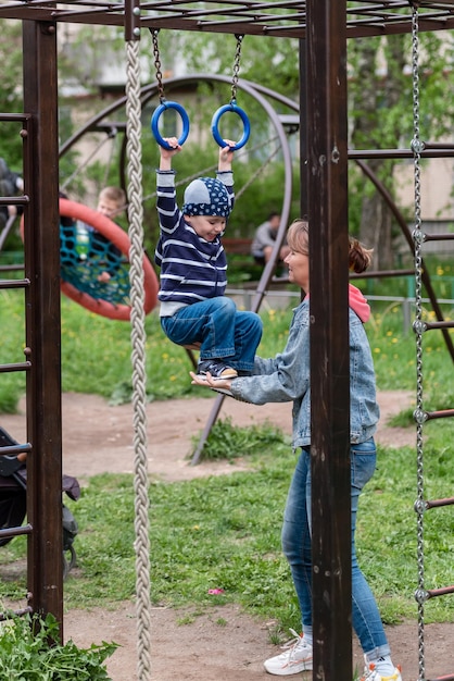 Um menino pequeno e sua mãe em um parque infantil