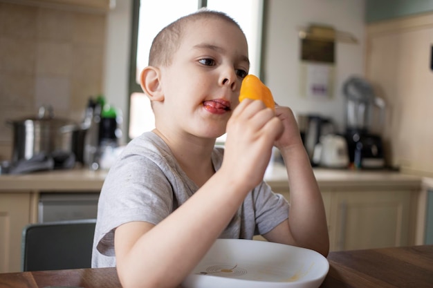 Um menino pré-escolar a comer gelado em casa.