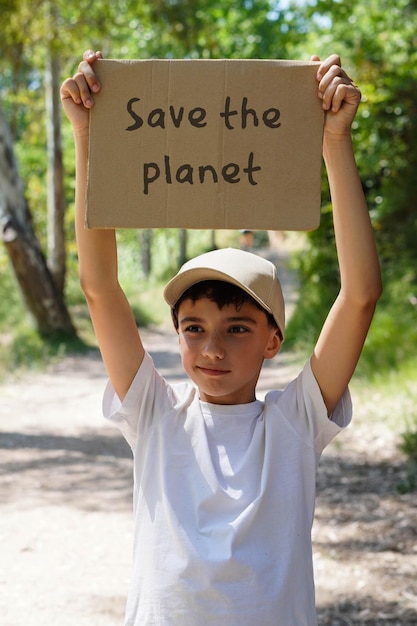 Um menino segura um letreiro que diz " Salve o planeta "