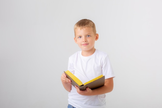 Um menino segurando uma pilha de livros em um fundo branco isolado