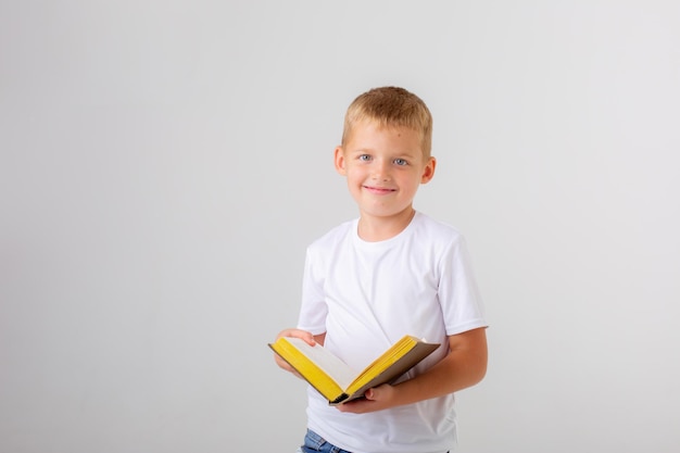 Um menino segurando uma pilha de livros em um fundo branco isolado