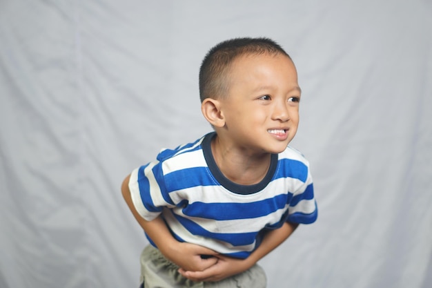 Um menino tem dor de estômago por não comer na hora certa