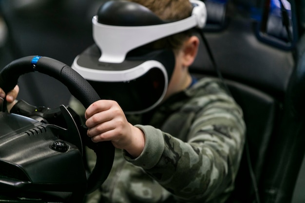 Um menino usando um fone de ouvido de realidade virtual joga um jogo de corrida