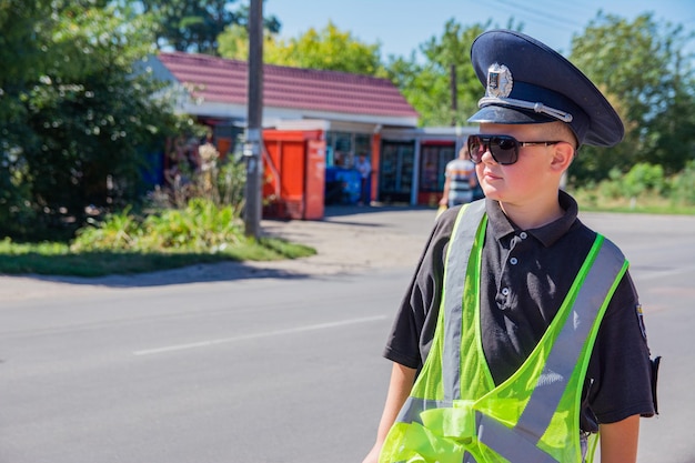 Um menino vestido como um policial joga como um agente de controle de tráfego