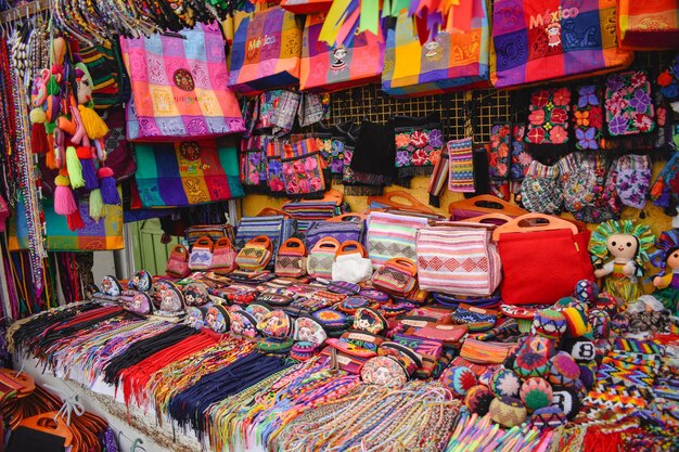 Um mercado com muitas bolsas e lenços em exibição, incluindo um que diz la quesa dulce