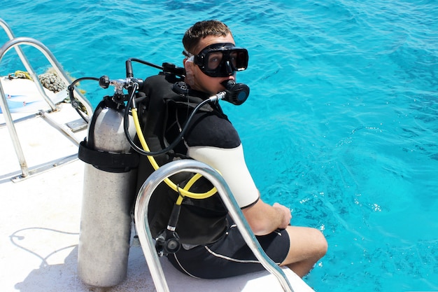 Um mergulhador em equipamento de mergulho está se preparando para mergulhar.