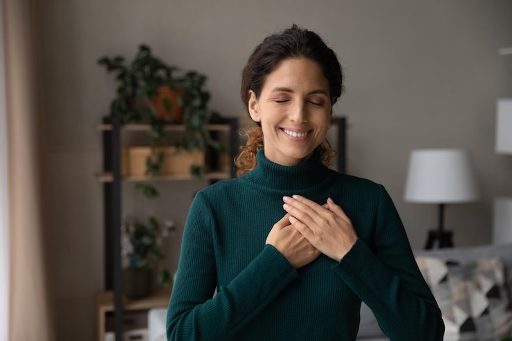 Foto um minuto feliz, uma jovem latina pacífica, sozinha, com os olhos fechados, as mãos no coração, rezando, agradecendo a deus pelas coisas maravilhosas da vida, uma senhora sincera, grata ao destino por cada bom momento.