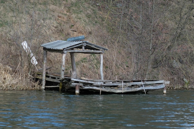 Um miradouro abandonado velho com uma ponte para pescar no rio b