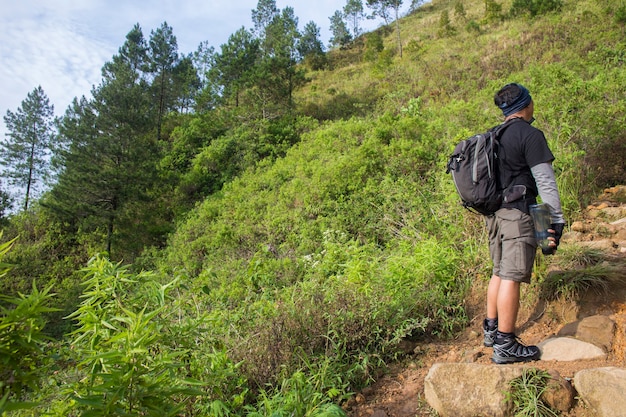 Um mochileiro viaja sozinho, com mochila nas montanhas