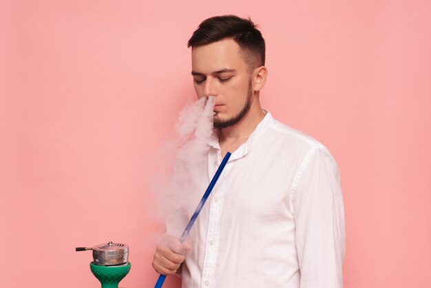 Um modelo masculino fuma narguilé, sheesha e se diverte.