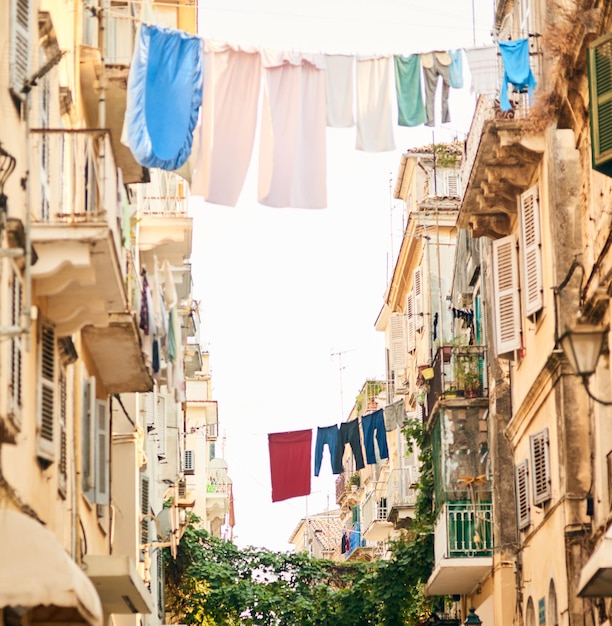 É um modo de vida diferente Foto de baixo ângulo de roupas penduradas em varais entre prédios em uma cidade estrangeira