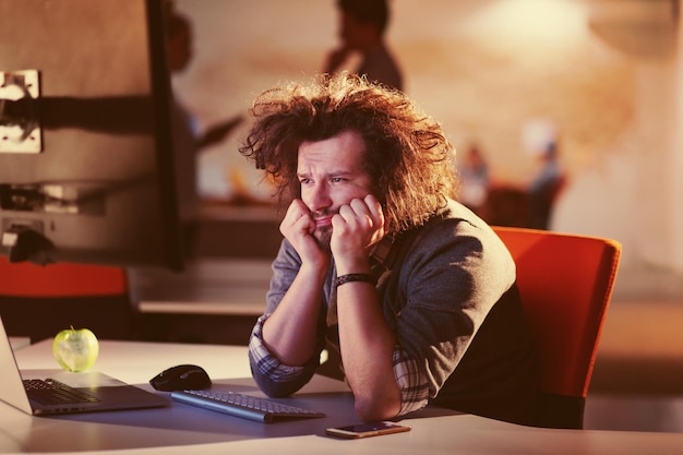 Um momento para relaxar. Jovem empresário casual cansado relaxando na mesa em seu escritório noturno