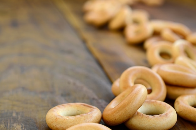 Um monte de bagels amarelos frescos encontram-se na superfície do velho escuro