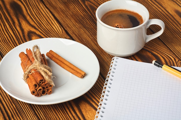 Um monte de canela de malha com uma corda, uma xícara de café e um notebook