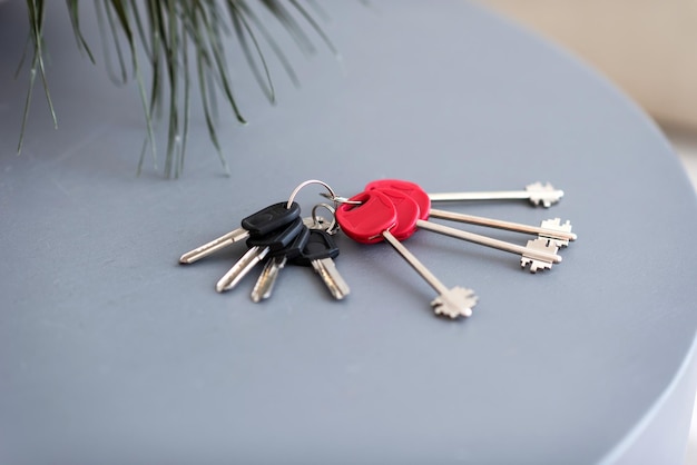 Foto um monte de chaves de casa está em uma mesa cinza conceito de compra em casa
