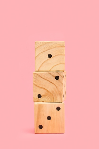 Um monte de dadinhos de madeira em um fundo rosa com espaço de cópia