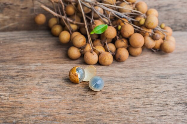 Um monte de Longan colocado em um fundo de madeira