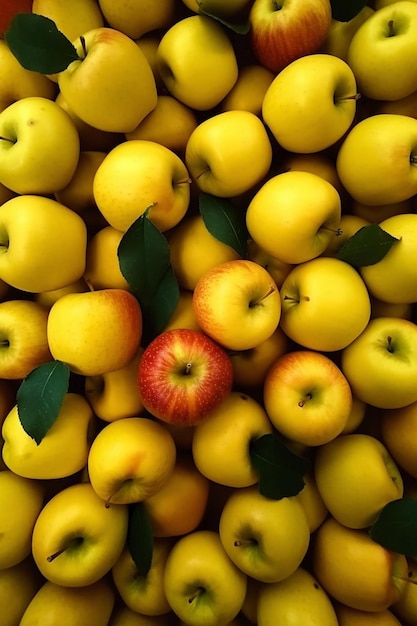 Um monte de maçãs amarelas com folhas verdes nelas