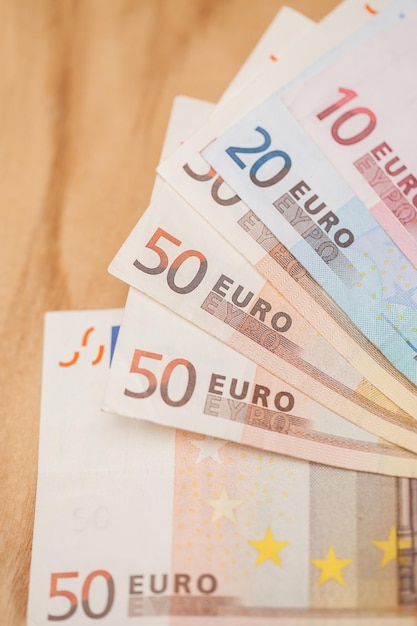 Um monte de notas de euro numa mesa de madeira