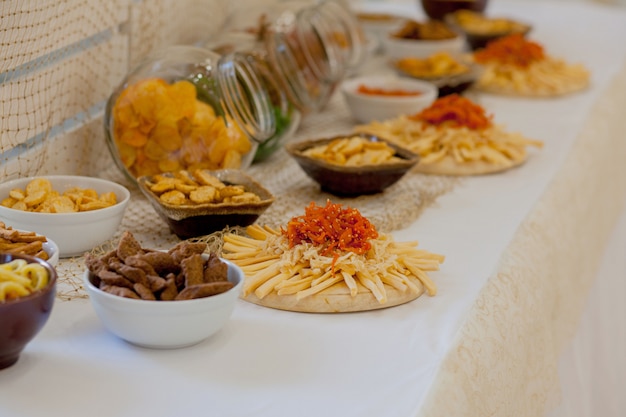 Um monte de salgadinhos em uma mesa, muitos queijos e bolachas em cima da mesa com salgadinhos