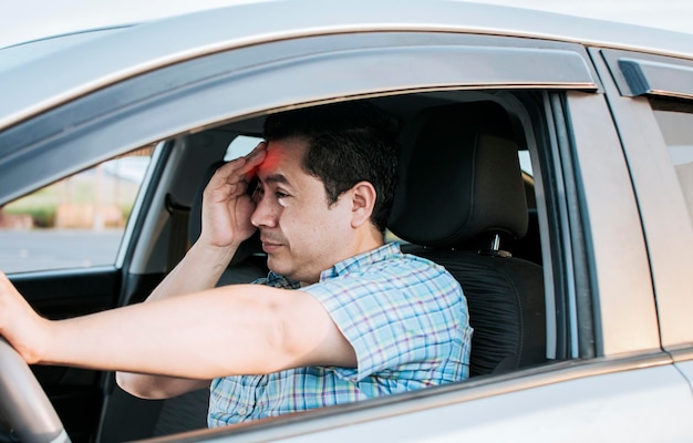 Um motorista com dor de cabeça no trânsito motorista cansado preso no trânsito conceito de um homem cansado em seu carro estressado Uma pessoa que sofre com dor de cabeça no trânsito