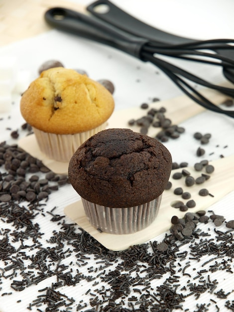 Um muffin de gotas de chocolate fica em uma bandeja com gotas de chocolate.