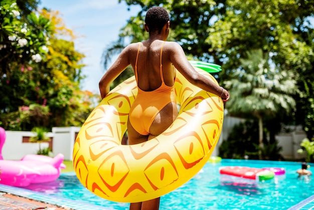 Um, mulher africana, ficar, por, a, piscina, com, um, inflável, flutuador, e, desfrutando, a, verão, tempo