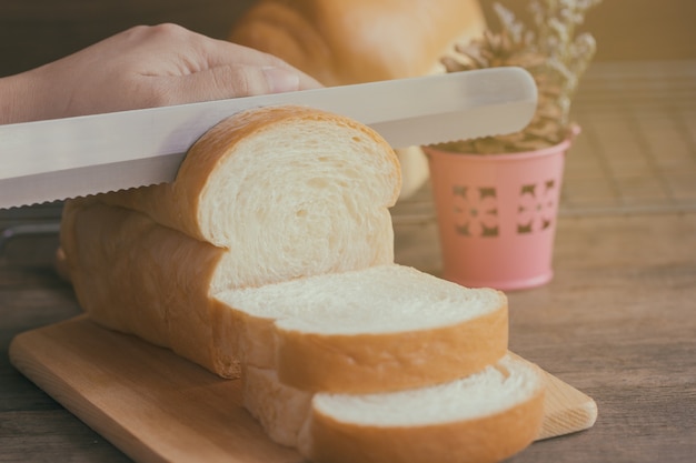 Um, mulher, faca uso, para, fatia, macio, e, pegajoso, pão delicioso