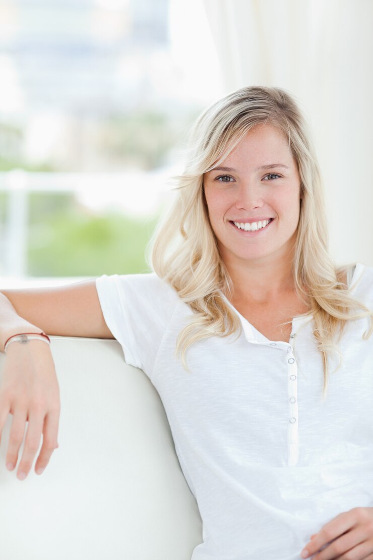 Foto um, mulher sorridente, sentar-se sofá, como, ela, olha, câmera