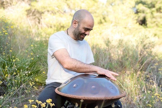 Um músico espiritual tocando um handpan de aço tradicional em um ambiente natural, música suave