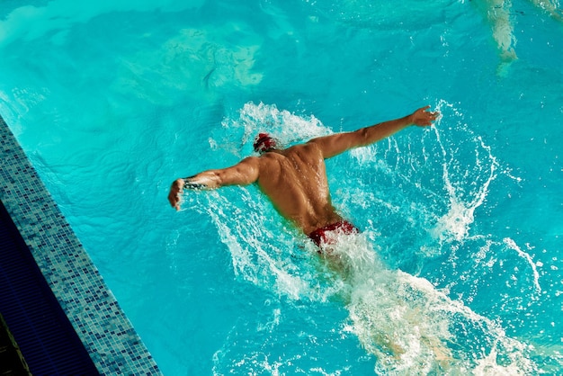 Um nadador masculino está treinando na piscina uma visão superior de um nadador nadando ao longo da pista na piscina