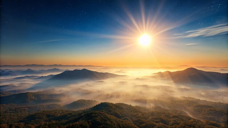Foto um nascer do sol sobre uma montanha com o sol brilhando através das nuvens