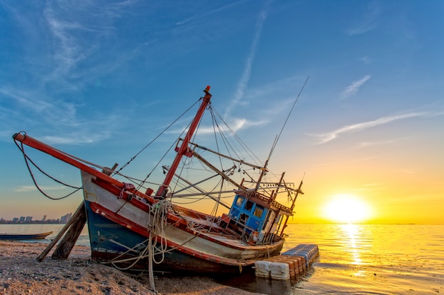 Um naufrágio abandonado na praia e luz solar durante o sol do sol do tempo