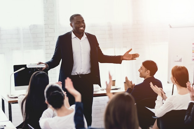 Um negro fala com funcionários do escritório em um seminário.