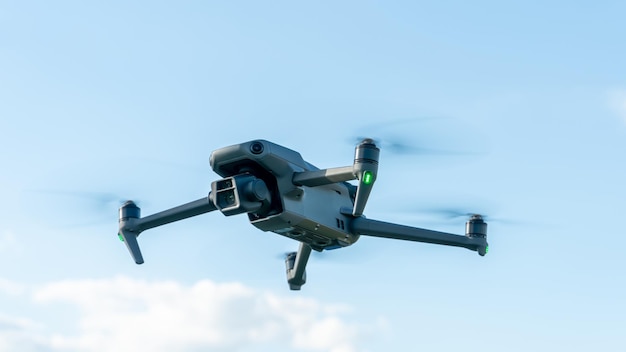 Um novo drone está pairando no ar contra o fundo das nuvens Detalhes do novo quadcopter closeup O uso de veículos aéreos não tripulados para exploração geológica e busca de campos de petróleo