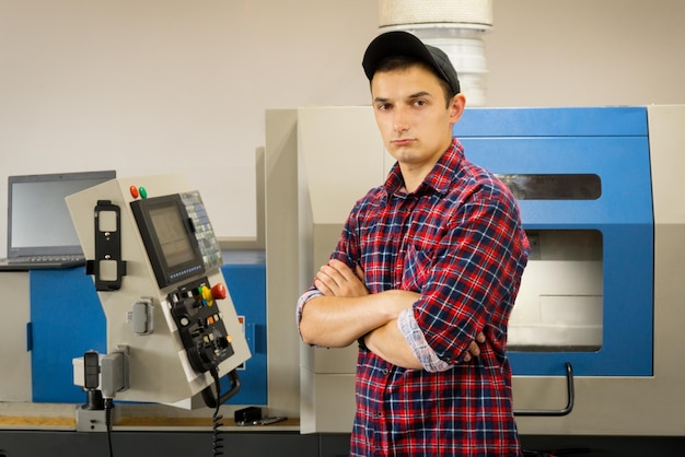 Um operador de cnc está perto do painel de gerenciamento de uma máquina-ferramenta