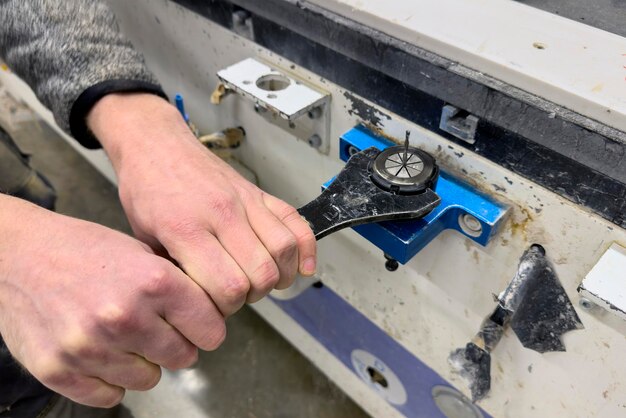 Um operador de máquina CNC muda um close-up de cortador das mãos de um operador de máquina cnc usando um