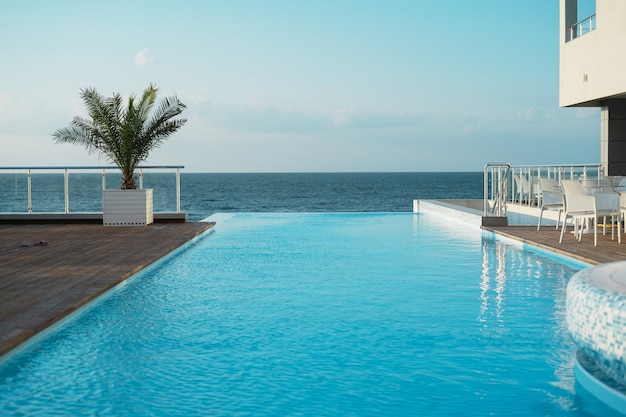 um ótimo resort. bela piscina com águas claras. hotel à beira-mar. água azul do dia ensolarado.